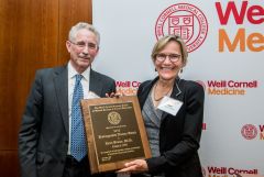 Two standing standing, holding a plaque